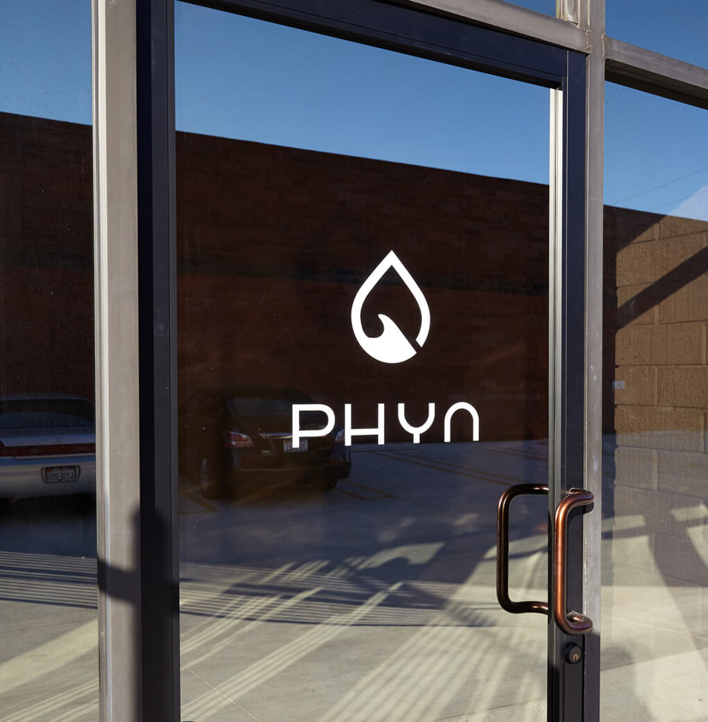 The Phyn logo on a glass office door