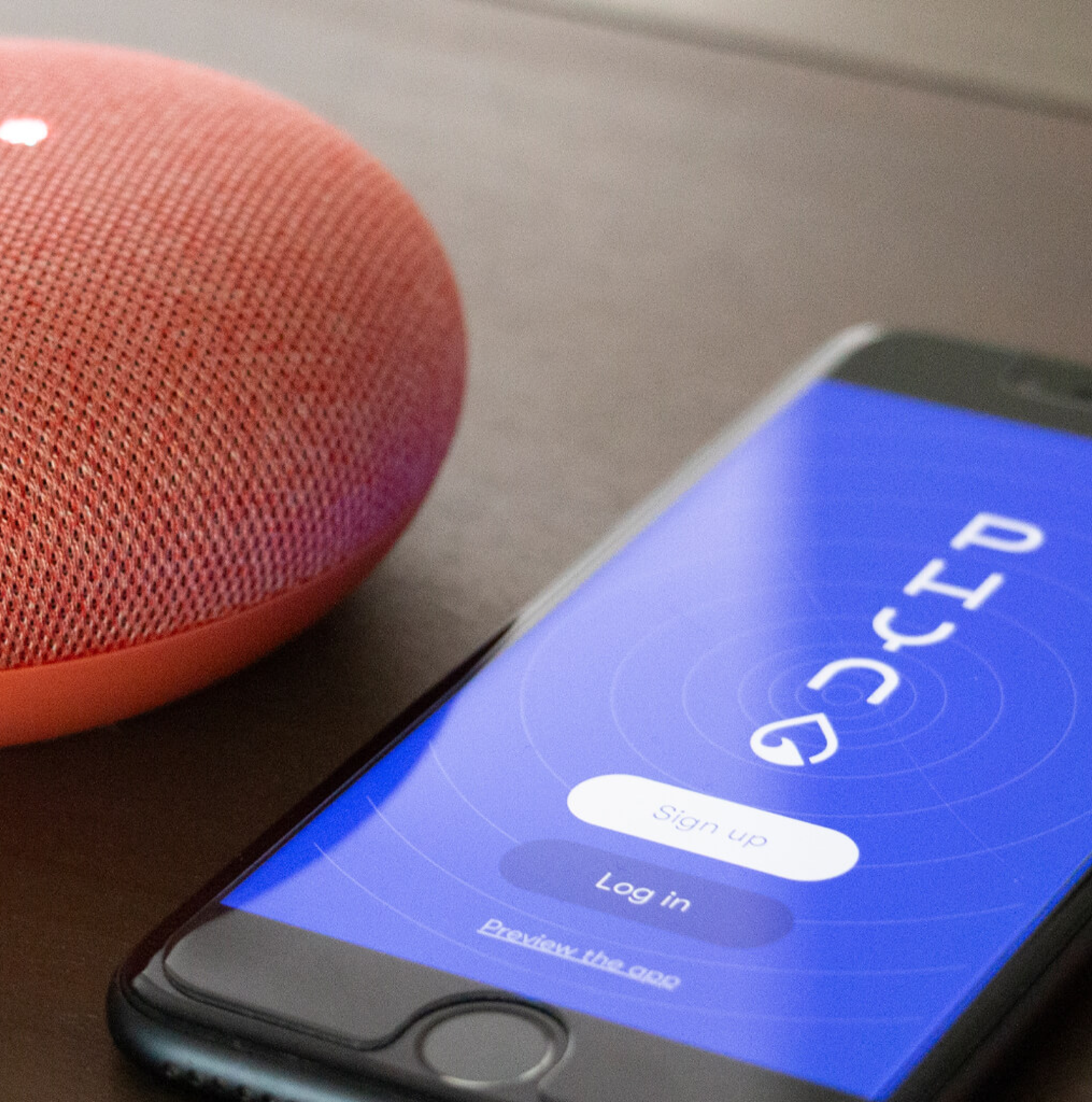 Phyn's display screen showing on an iphone resting on a surface next to a bluetooth speaker.